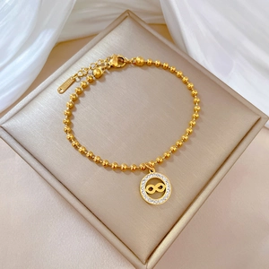 Gold beaded stainless steel bracelet featuring an infinity symbol with micro-inlaid rhinestones