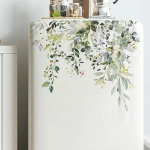 Kitchen scene showing watercolor green plant stickers on a white refrigerator surface
