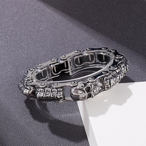 Nahaufnahme eines Vintage-Stahl-Totenkopf-Armbands mit mechanischer Gliederkette auf Stein