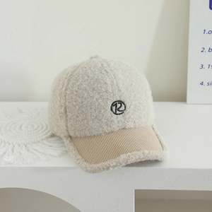Dettaglio del cappello beige in pile con logo R ricamato e visiera in velluto a coste