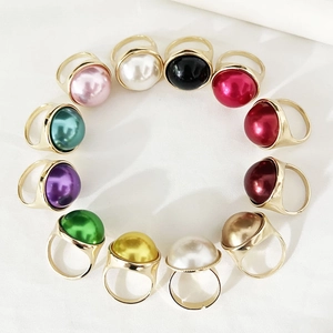Detailed top view of twelve gold rings with colorful round pearls arranged in a circle