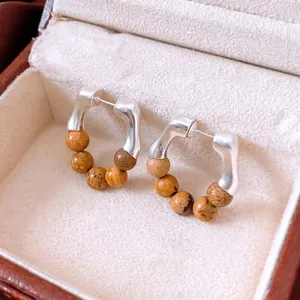 Vintage stone beaded hoop earrings with marble texture on beige velvet jewelry box