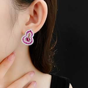 Detail of hulu-shaped silver earring with pink zircon stones worn by a model