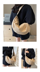Close-up of the beige nylon crossbody bag with adjustable strap and crescent shape