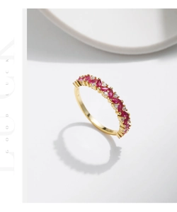Detail of gold S925 silver ring with marquise red gems and sparkling clear stones