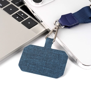 Detail view of adjustable navy blue fabric phone lanyard with metal clip on white surface
