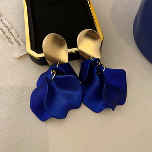 Close-up of Klein blue tassel petal earrings with golden geometric semi-circle studs