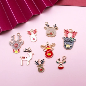 8-piece set of gold Christmas reindeer enamel charms on a clean pink background