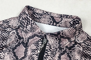Detailed close-up of snake print collar and metal zipper on slim fit streetwear outfit