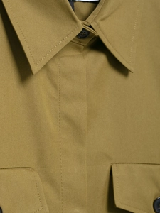 Detail of khaki cotton utility shirt featuring a pointed collar and stitched chest pocket