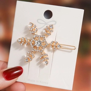 Elegant gold snowflake hair clip featuring sparkling rhinestones and a metal barrette