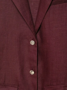 Detailed macro view of burgundy linen blazer notched lapel and metallic button texture