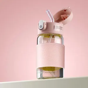 Detail der rosa Lederhülle auf einer Glasflasche mit Strohhalm und Klappdeckel