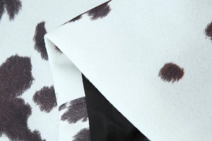 Gros plan sur la texture du tissu imprimé vache marron et blanc pour vestes courtes
