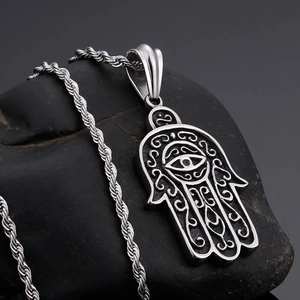 Silver Hamsa Hand pendant with evil eye on black stone background and twist chain necklace