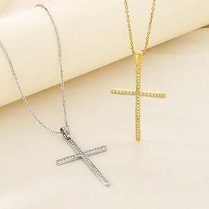 Hip hop rhinestone cross pendants in gold and silver steel on a neutral background