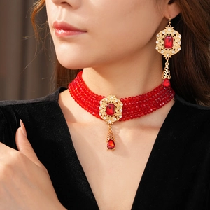 Detail of red beaded choker set with gold filigree pendant and ruby-like gemstones
