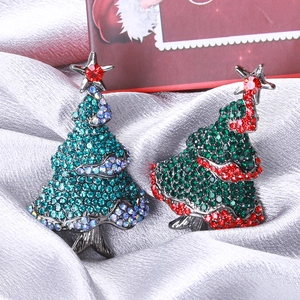 Detail view of sparkling rhinestone Christmas tree brooches on silk fabric