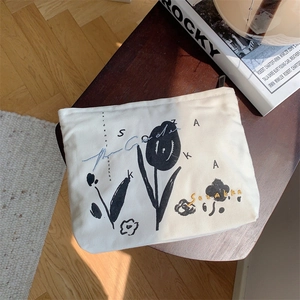 Detailed close-up of a floral canvas makeup bag on a wooden stool with a cozy home setting