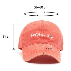 Detail of coral washed cotton baseball cap showing small letter embroidery and dimensions