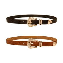 Detailed view of black and brown Western style belts with ornate gold embossed buckles