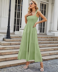 Détail d'une robe longue vert sauge avec bustier froncé et bretelles à nœuds élégants