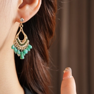 Bohemian teardrop tassel earrings with green beads shown on model for a vintage style