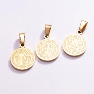 Detailed view of Saint Benedict Medals in gold-plated stainless steel with relief patterns