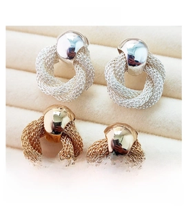 Close-up of woven vintage style camellia earrings in gold and silver plating
