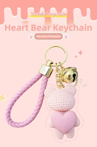 Pink crocheted heart bear keychain with golden bell and woven wristlet strap