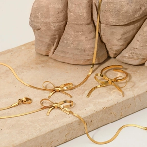 Parure de bijoux élégante en forme de nœud doré avec collier, bracelet et bague