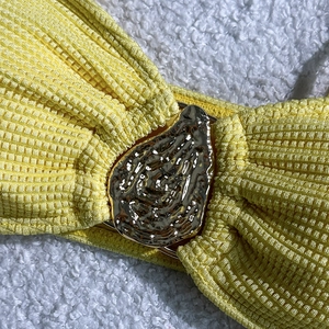 Detail view of yellow waffle textured fabric with a large decorative gold metal buckle
