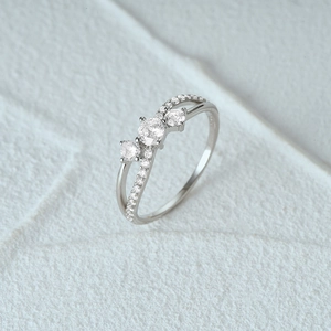 Macro view of S925 silver ring featuring criss-cross band and three sparkling diamonds