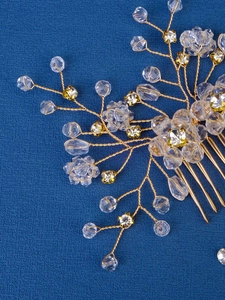 Detalle de peineta de novia artesanal dorada con perlas de cristal y diseño de flores