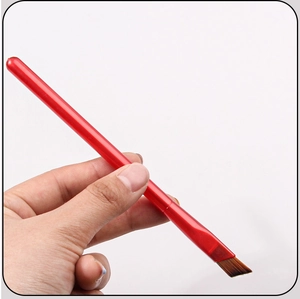 Detailed close-up of a red angled eyebrow brush featuring synthetic brown bristles