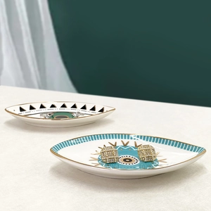 Close-up of ceramic evil eye jewelry trays with gold edges for rings and earrings