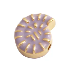 Macro shot of snail-shaped gold-plated metal pendant with purple enamel spiral pattern