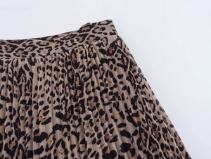Dettaglio della gonna a pieghe in chiffon leopardato con cuciture in vita e trama del tessuto