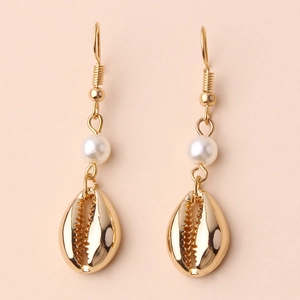 Bohemian gold seashell earrings with white round pearls on a soft beige background