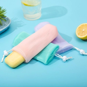 Detail of 6-layer foaming net bag with drawstring holding solid yellow soap bar