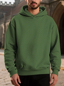 Detailed close-up of men's dark green hoodie featuring 3D diamond jacquard texture pattern