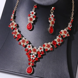 Macro detail of red teardrop crystals and gold V-neck bridal necklace on display