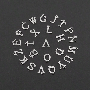 Silver A-Z initial heart pendants set in a circular array on a dark matte background