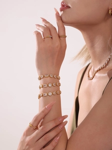 Lussuosi bracciali dorati con cristalli di zircone 5A e set di anelli abbinati sul modello