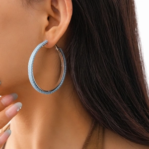 Modern light blue denim wrapped large hoop earrings for women worn by a model