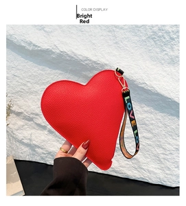 Détail du sac à main cœur rouge avec texture litchi et lettrage LOVE sur la bandoulière
