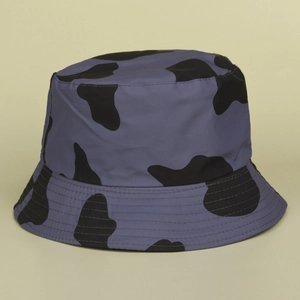 Détail d'un chapeau bob réversible avec motif vache et surpiqûres sur le bord violet
