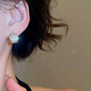 Macro shot of 18k gold plated earring featuring a large sparkling zircon on a wide band