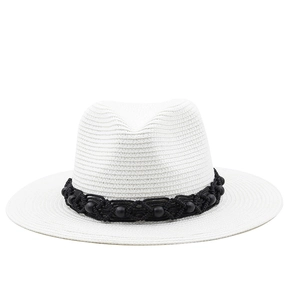 Detailed view of white straw Panama hat with black bead woven band and texture