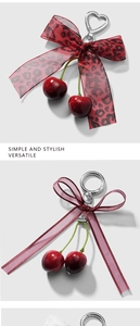 Detail of cherry keychain with leopard print bow and heart metal clasp accessory